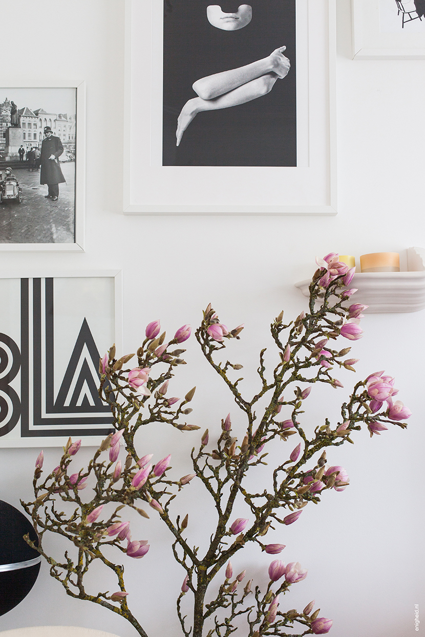 Huge magnolia branch with flowers in my living room. Art on the wall by Tyler Spangler poster, Bla-poster by One Must Dash and work of art by Marijke Timmerman. The console is a Boschroom designed by David Derksen, with Scholten and Baijings Arita 1616 ceramics on top of it | Enigheid