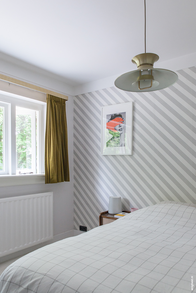 Bedroom in the home of Iris Vank, with vintage ceiling light, Hay bedding (by Scholten and Baijings), artwork by Tyler Spangler and Zilverblauw wallpaper | Enigheid