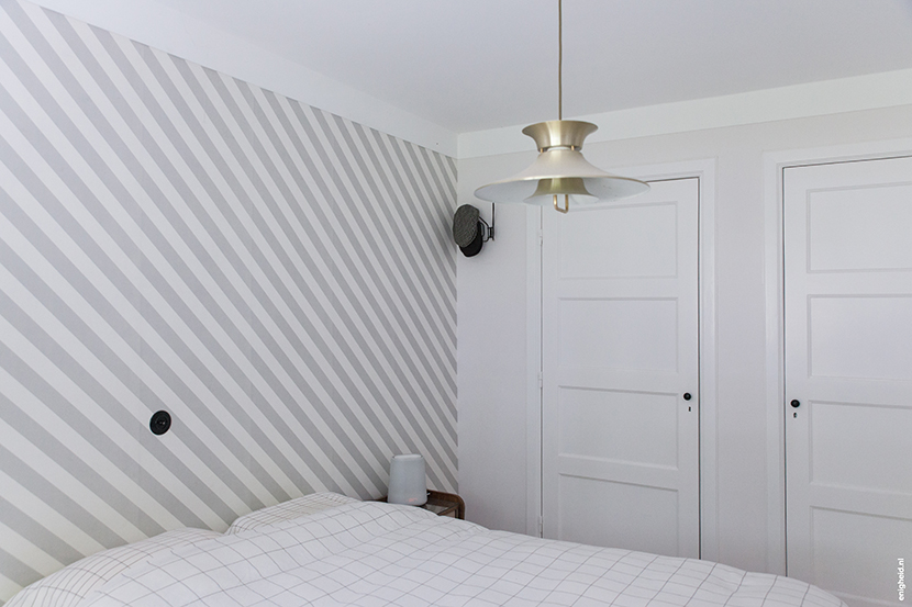 Bedroom in the home of Iris Vank, with vintage ceiling light, Hay bedding (by Scholten and Baijings) and Zilverblauw wallpaper | Enigheid