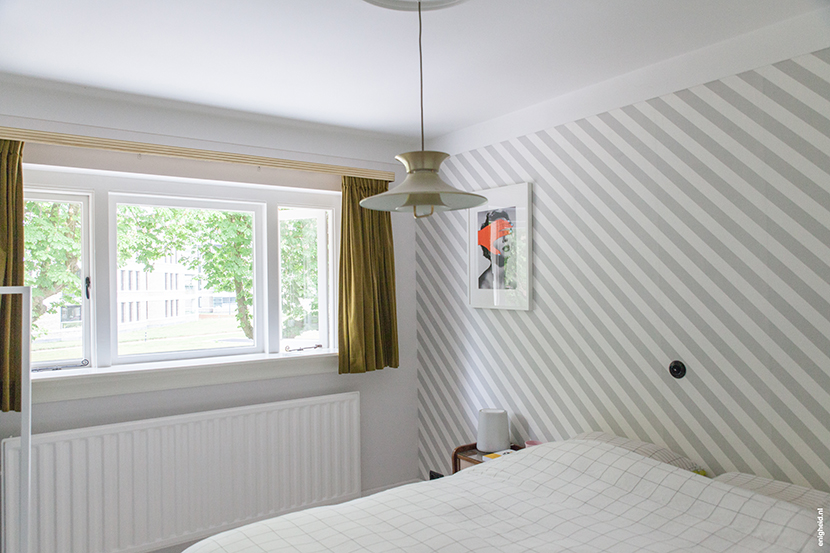 Bedroom in the home of Iris Vank, with vintage ceiling light, Hay bedding (by Scholten and Baijings), artwork by Tyler Spangler and Zilverblauw wallpaper | Enigheid